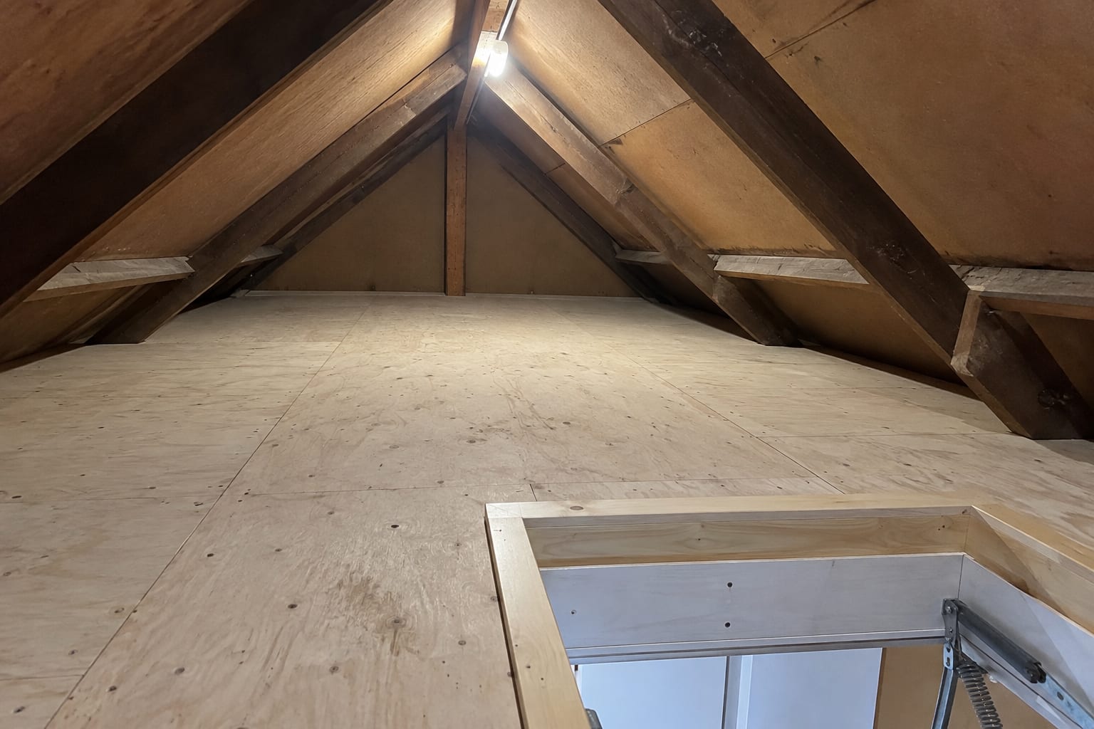 Nieuw gebouwde houten vlieringvloer op de balklaag onder het schuine dak